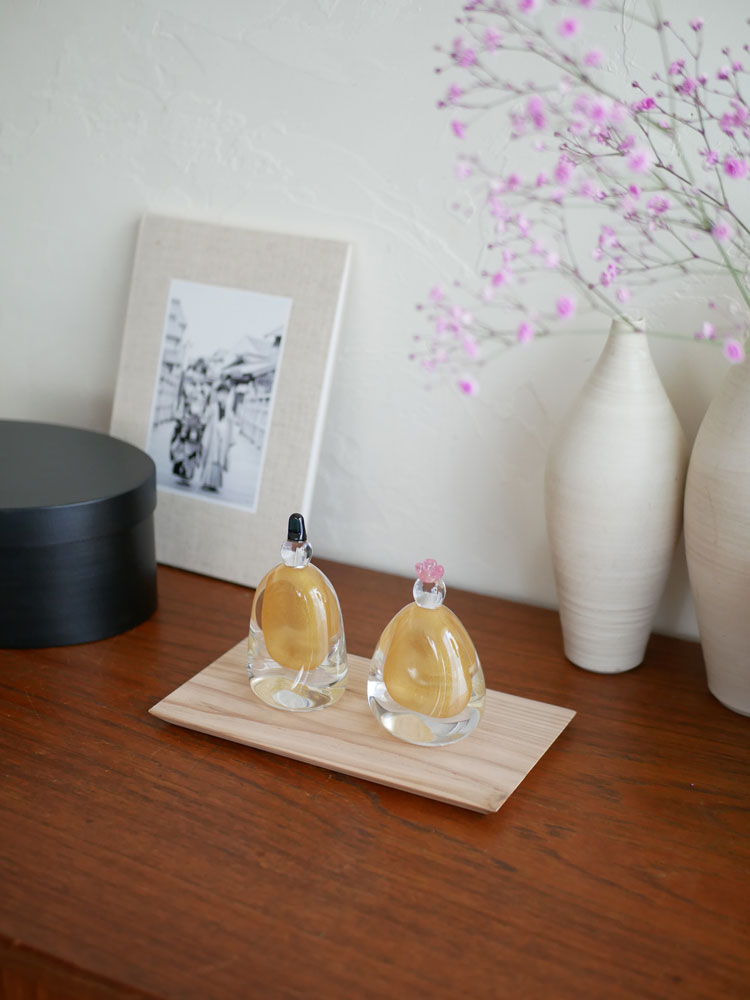 硝子屋 PRATO PINOのガラス製お雛様セット。お内裏さまとお雛さまが木箱と飾り台に飾られており、手作りの繊細なデザインが特徴です。