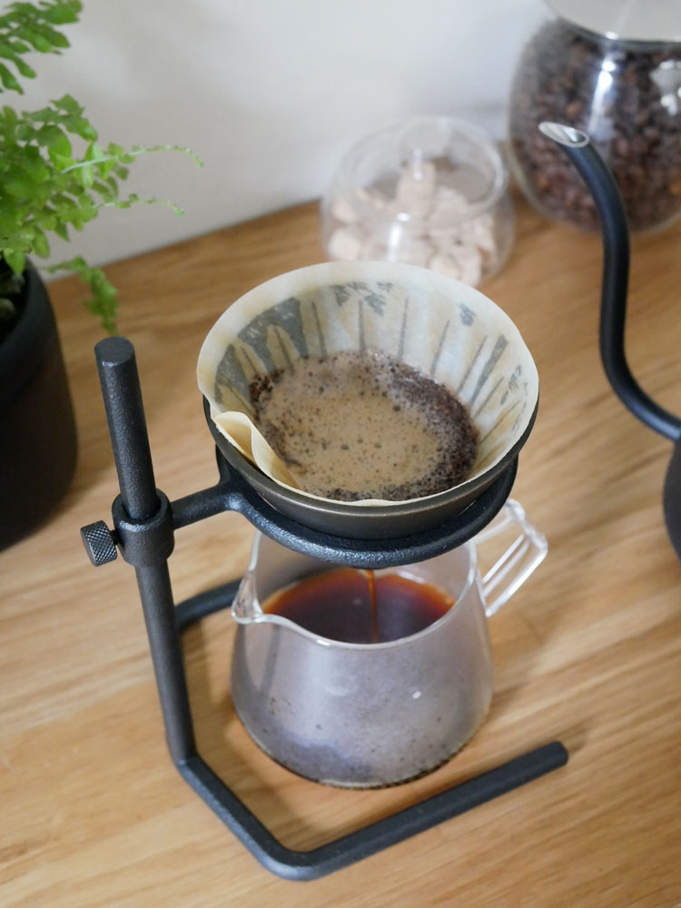 黒色のKINTOブリュワースタンドセットとカップが置かれた静物写真