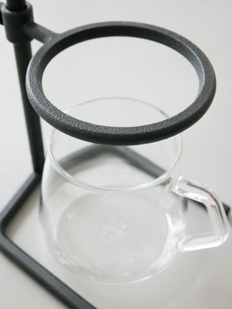 キントー製ブラックブリュワースタンドセット。ステンレス製スタンドにガラスカップ、蓋、フレンチプレスが配置されたテーブルウェアセット