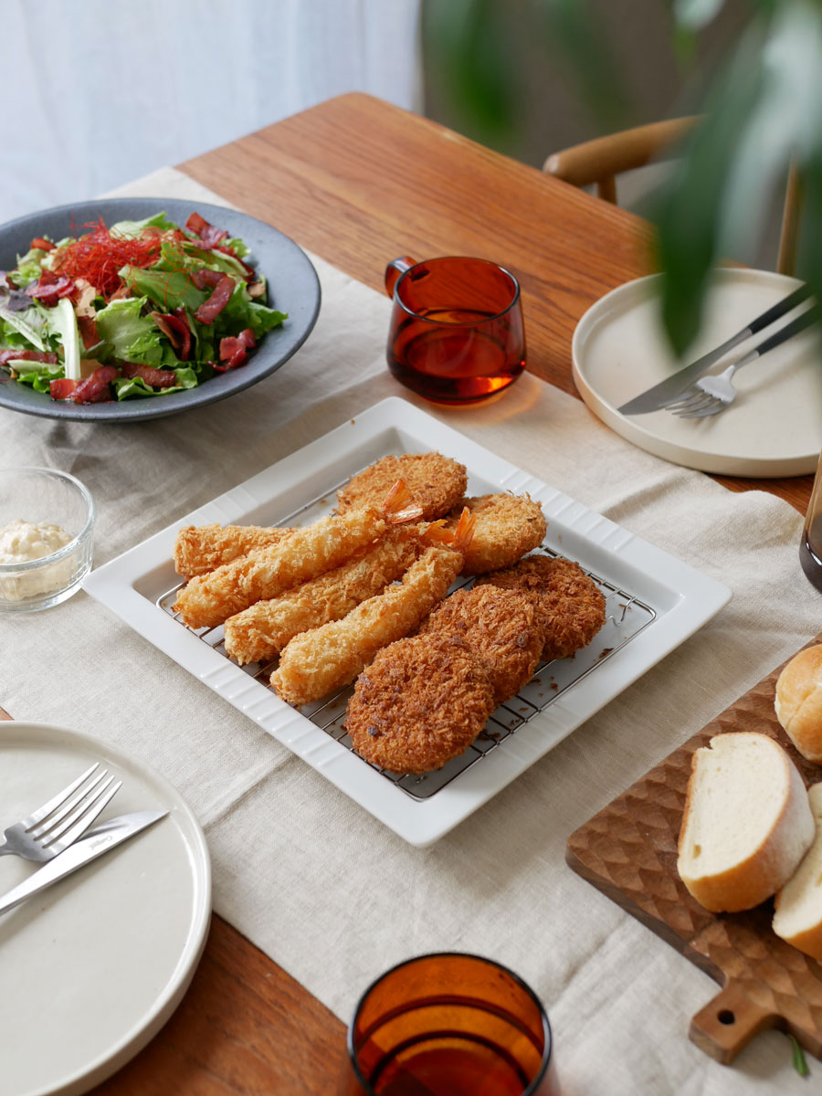 下村企販の日本製スクエアディッシュ アミ付に揚げ物が盛られた食卓の様子