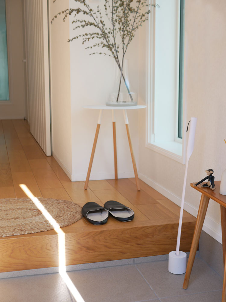 木製フローリングの床に花鉢入りの観葉植物が配置された室内の風景