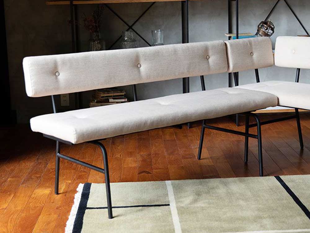 グレー色のサムノルドベンチソファがオーク材の木製フロアに配置されたリビングルーム