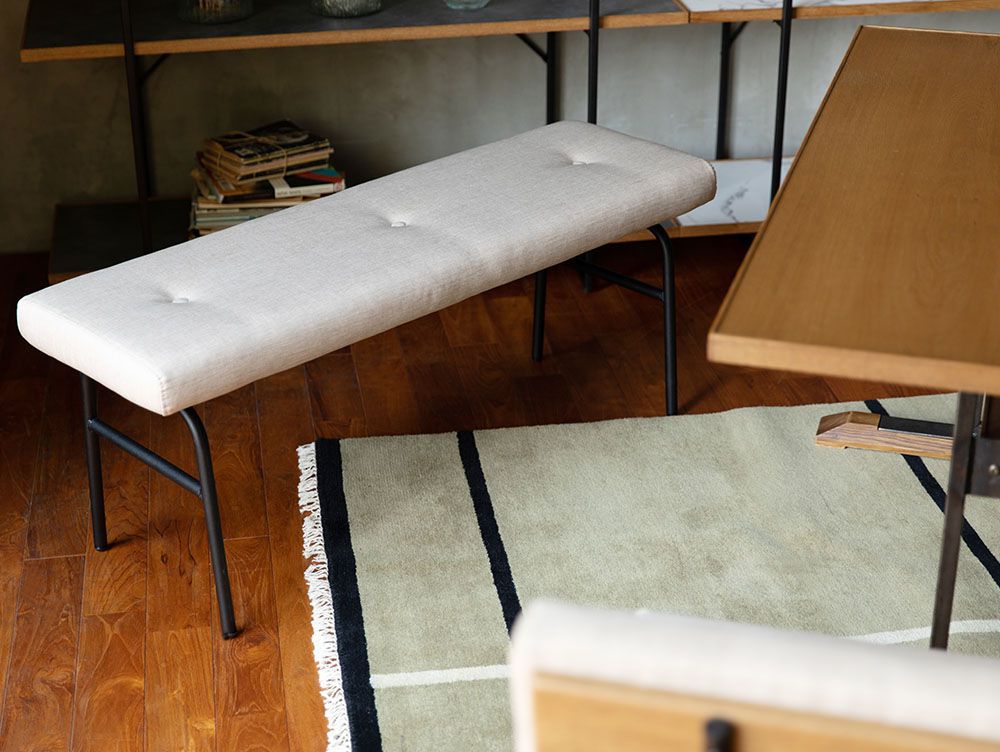 オーク突板とスチールパイプを使用したadepecheのsam-nord サムノルド クッションベンチが、木製フローリングの上に配置されています。