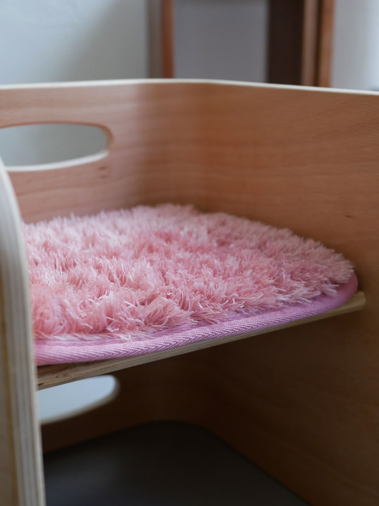 HOPPL（ホップル）コロコロチェア専用のピンク色マイクロファイバーチェアパッドが木製の床の上に配置されている様子
