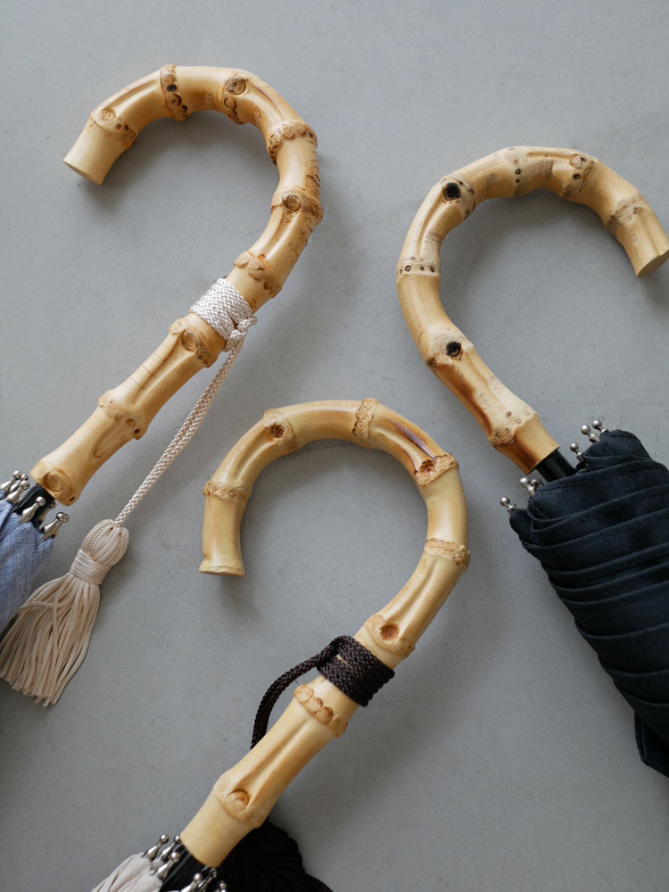 バンブーハンドルとブラス製骨を持つビコーズのプレーンカラー長傘と折りたたみ傘の写真