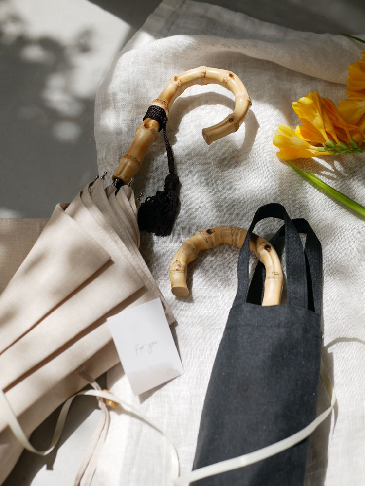 ビコーズのプレーンカラー長傘。竹製ハンドルと防水加工されたポリエステル生地を使用し、手開きタイプでセーフガード付きの晴雨兼用デザイン。