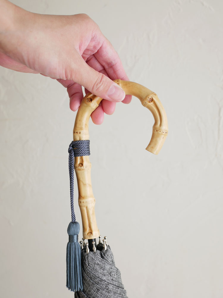 ビコーズのプレーンカラー長傘。8本の骨とバンブーハンドルを持ち、防水・UVカット加工されたポリエステル素材で晴雨兼用に最適なデザイン。