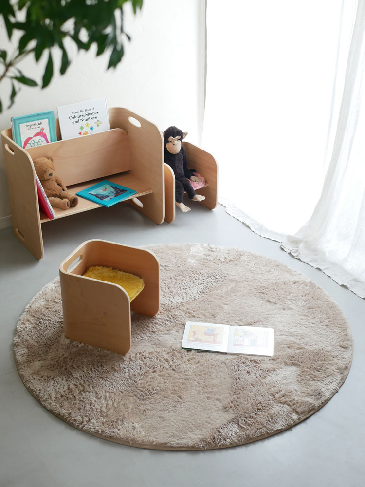 ホップルの130cm円形ラグが木製フローリングのリビングルームに敷かれ、子どもが快適に遊んでいる様子