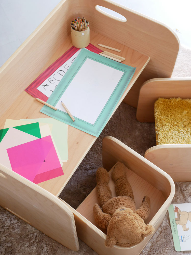 ポリエステル100％製の直径130cmホップル円形ラグが、プラスチック製のボックスや子供用おもちゃと共に収納された明るい室内の様子