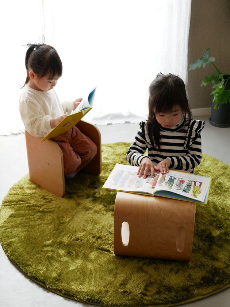 ホップルの直径130cmの円形ラグがリビングルームに敷かれ、子供が快適に座って遊んでいる様子