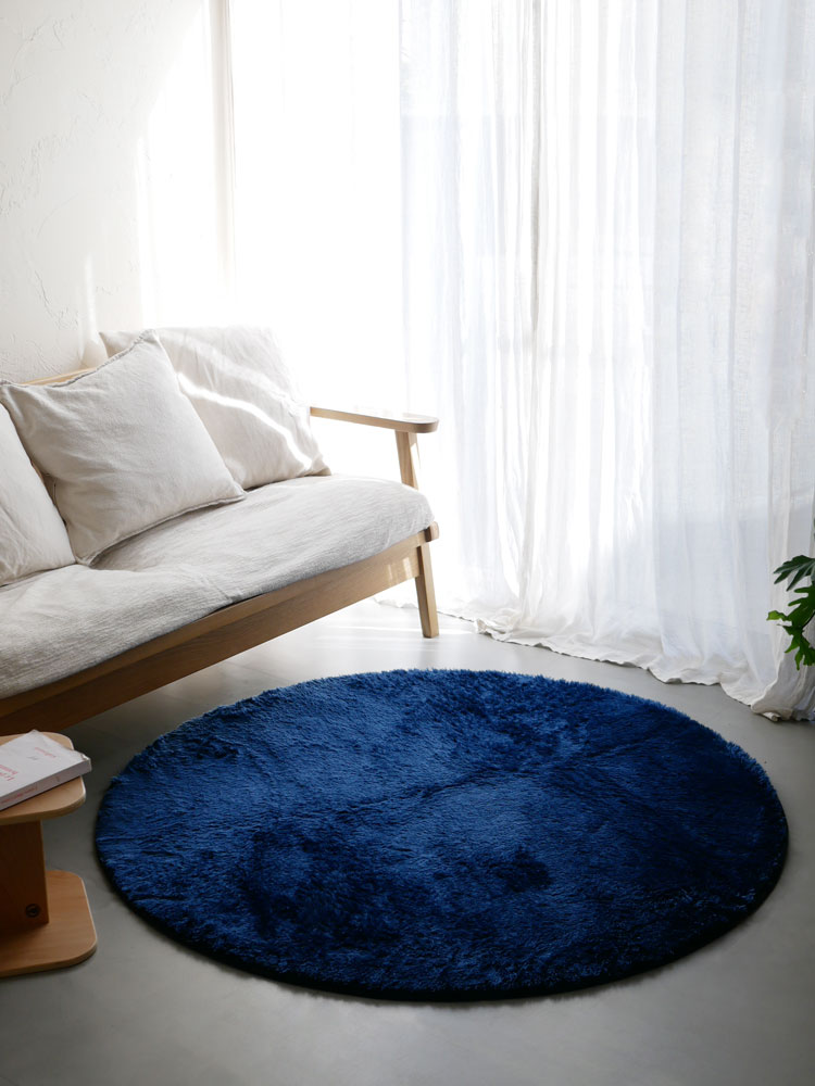 リビングルームの木製フロアに敷かれた【HOPPL/ホップル】直径130cmのポリエステルマイクロファイバー製円形ラグ