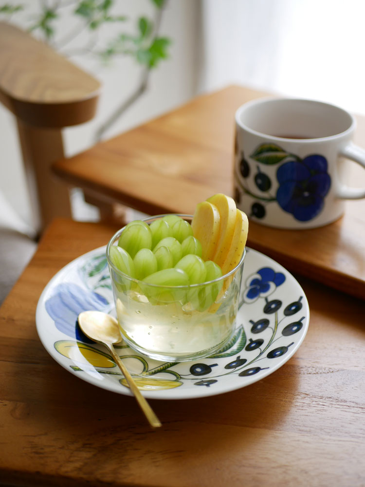 アラビア製の白磁ティーカップとソーサーが果物と共にテーブルに並べられている様子