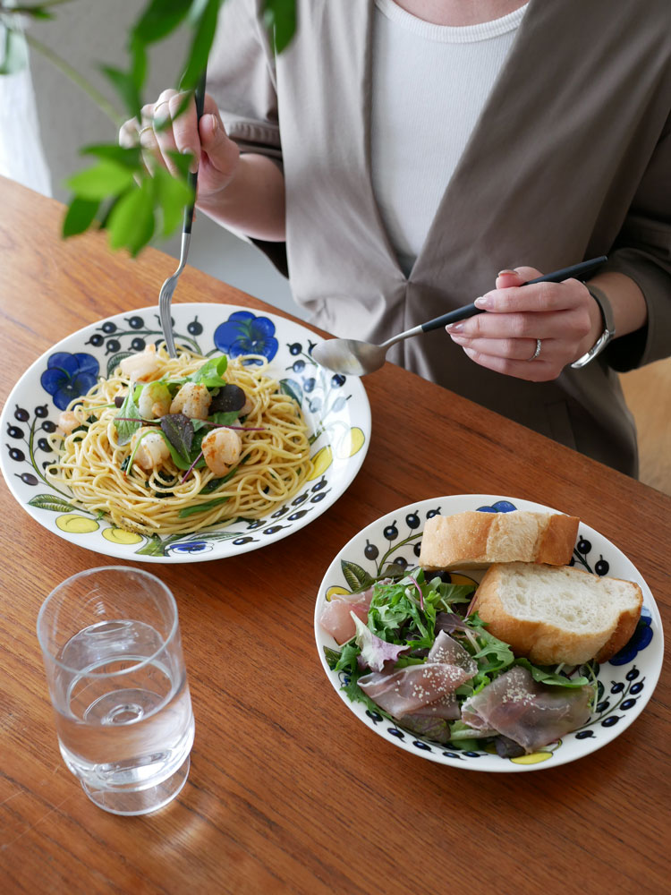 アラビアのパラティッシオーバルプレートに盛られたアルデンテスパゲッティと食器がテーブルに並べられた食事シーン