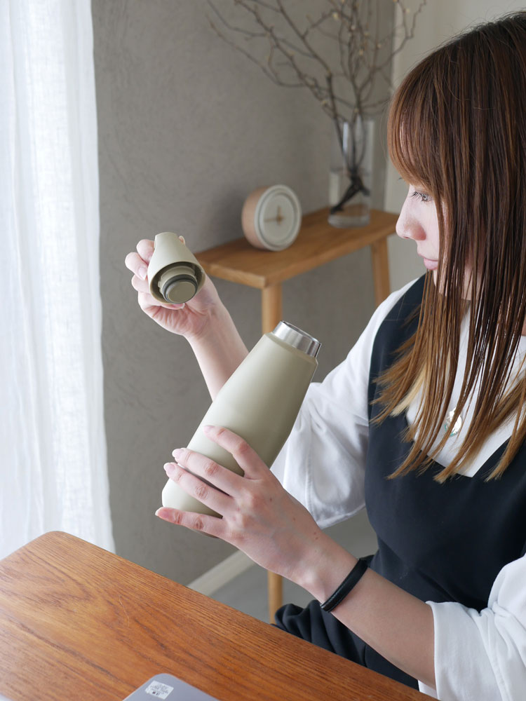 KINTOキントーのトレイルタンブラーと調整可能なストラップを持つ手