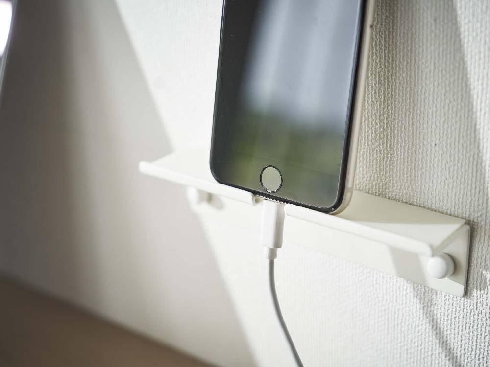 壁に取り付けられたタワー型ウォールスマートフォンホルダーにスマートフォンがセットされている様子