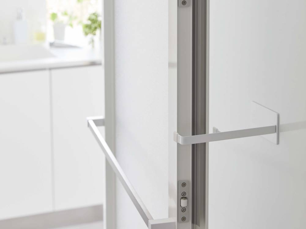 浴室のガラス扉に取り付けられたタワー マグネット浴室扉ストッパーと周囲の棚が配置されたインテリア