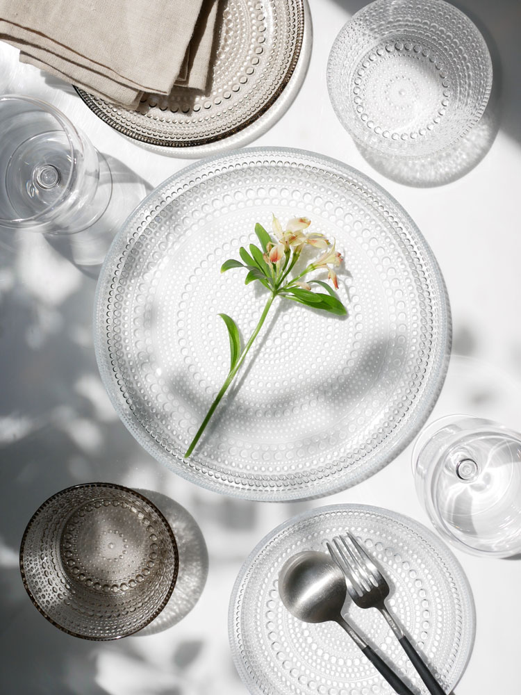 フィンランド製イッタラの無鉛ガラスカステヘルミプレートが、銀製のカトラリーと共にセッティングされたダイニングテーブルに配置されている様子