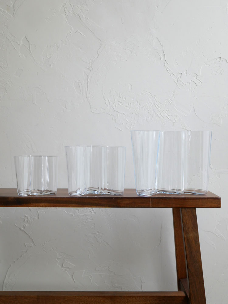 フィンランド製イッタラ アルヴァ・アアルトコレクションのベースに透明なハイボールグラスとオールドファッションドグラスが並べられたテーブルウェアの静物写真