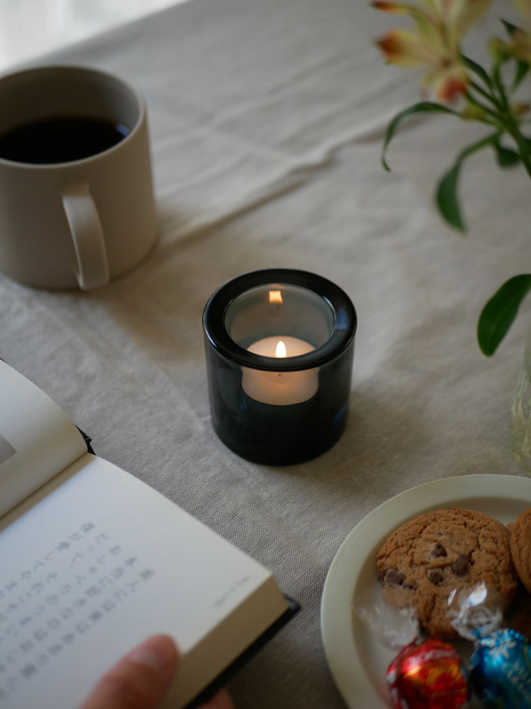 フィンランド製無鉛ガラスのiittalaキビキャンドルホルダーにロウソクが灯された円筒形のシンプルなデザイン