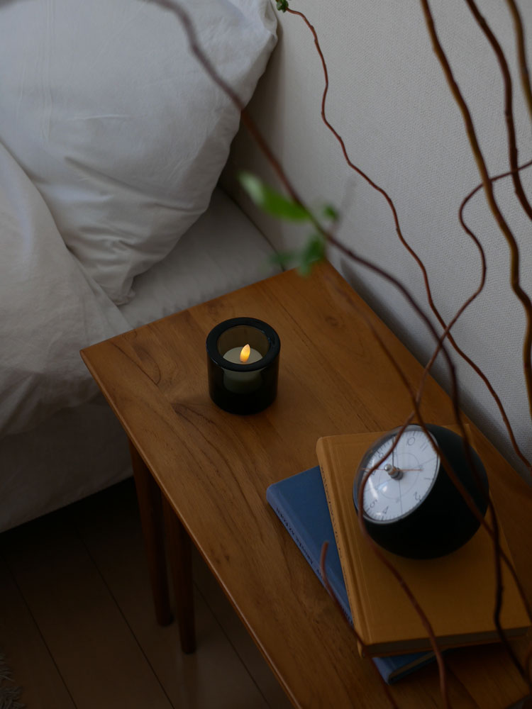 フィンランド製イッタラの無鉛ガラスキビキャンドルホルダーにキャンドルが灯され、木製フローリングの上に配置された静物写真