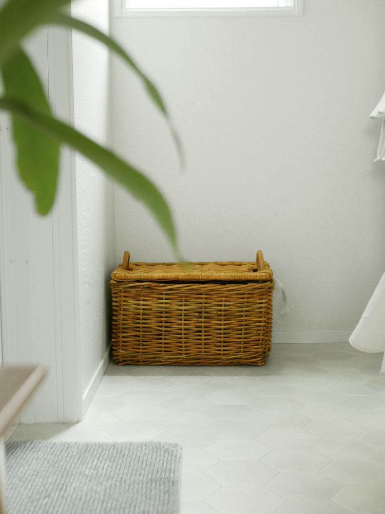 Creerクレエの皮つきラタン製運べる収納バスケットが木製フローリングの上に置かれている