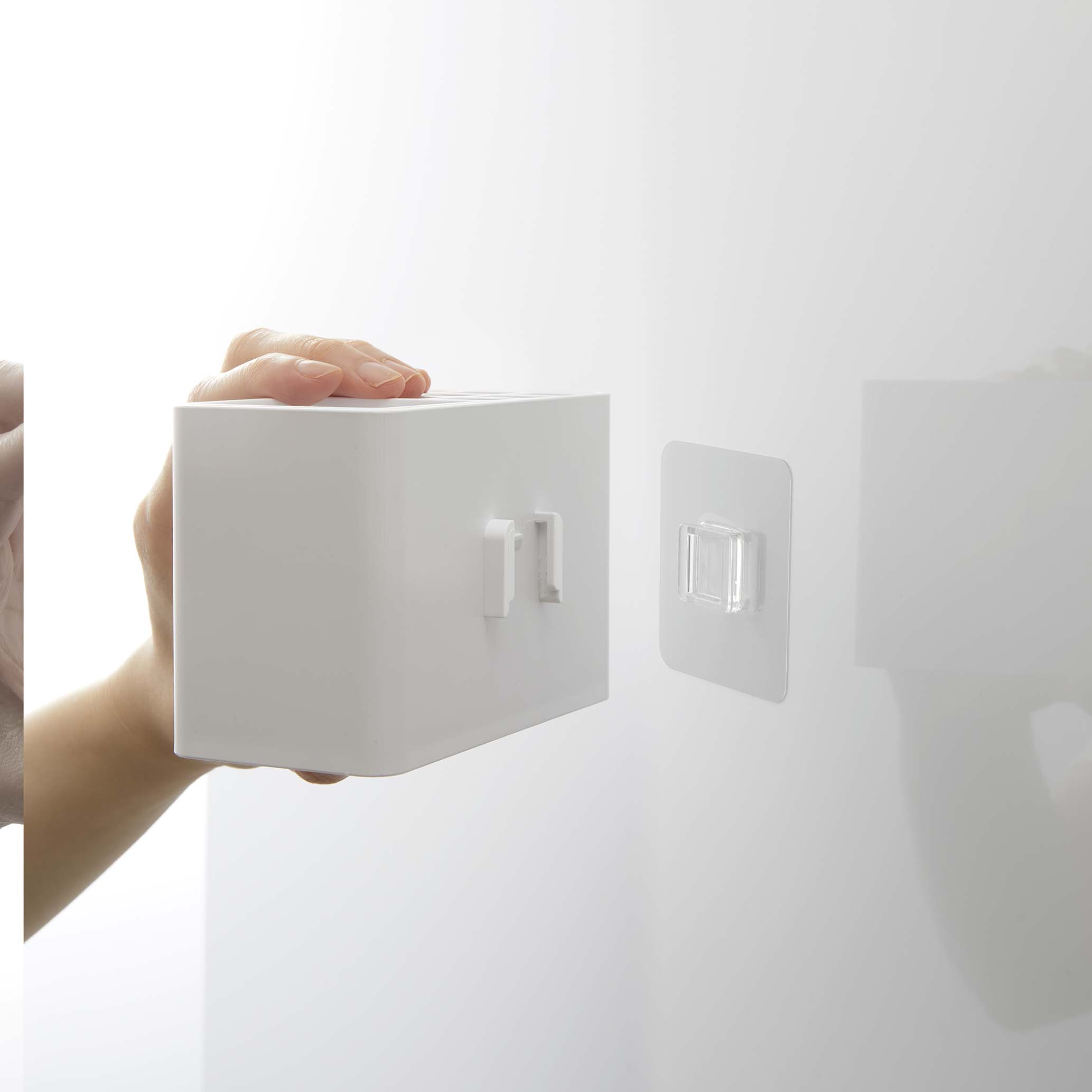 MISTのフィルムフック歯ブラシスタンドが光沢のある壁面に取り付けられている様子