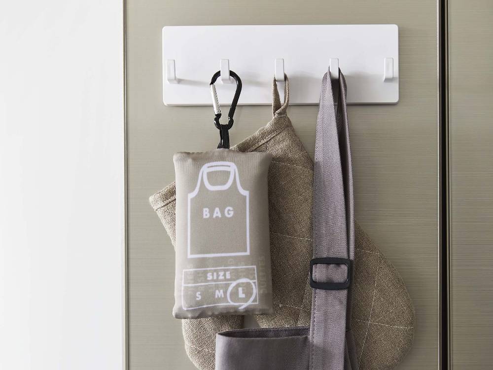 ABS樹脂製の5連フィルムフックに衣類とレザー製バッグが掛かっている様子