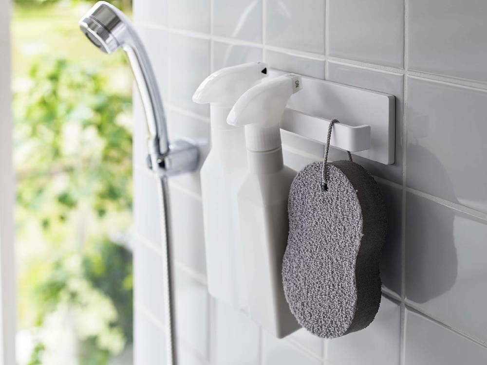 浴室の洗面台に取り付けられたMISTフィルムフックタオルハンガーがタオルを掛けている様子