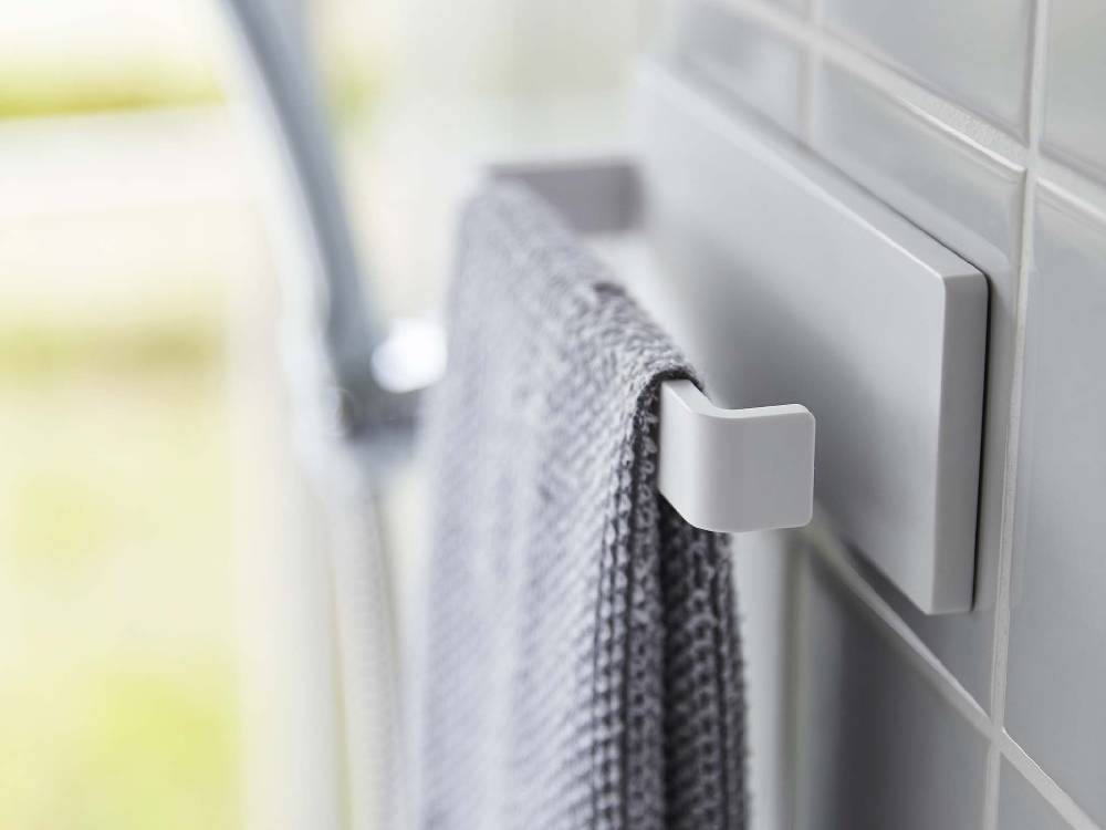 【MIST/ミスト】フィルムフック タオルハンガー W18が洗面所の壁面に取り付けられ、タオルを掛けている様子