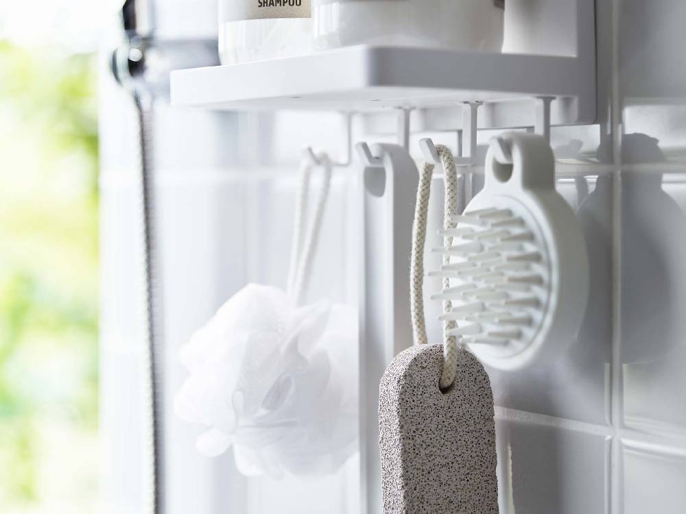 MIST（ミスト）のフィルムフックトレーW18が浴室のステンレスタイルに取り付けられ、プラスチック製の家庭用品や調理器具を整理している様子