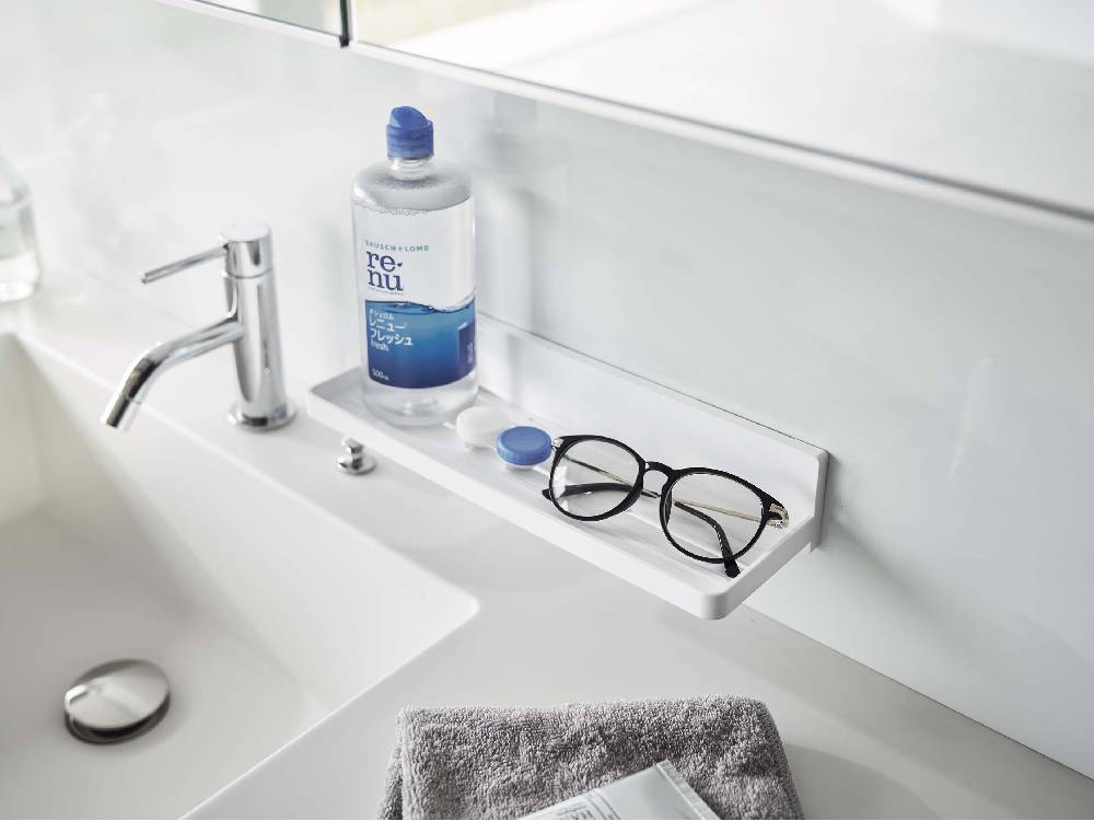 バスルームのシンク横に設置された【MIST/ミスト】フィルムフック トレー W30。4つのフックが付いており、ボトルなどの小物を整理するための収納具です。