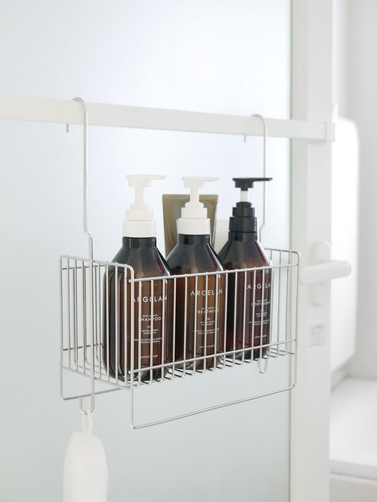 18-8ステンレス製の引っかけお風呂バスケットが浴室の棚に掛けられ、ボトルや石鹸ディスペンサーなどの日用品が整然と収納されている様子