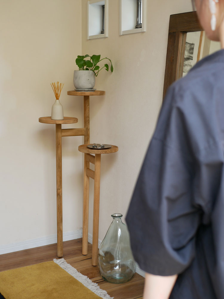 ナチュラルチーク無垢材を使用したサンフラワーラタンのステップトレイテーブル。高さ100cmの3段木製棚と安定した脚が特徴的です。