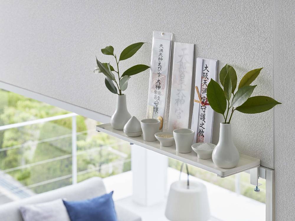 リビングルームに設置されたTowerブランドの幅45cm鴨居上神棚。周囲には観葉植物や花瓶、デザイン照明が調和しています。