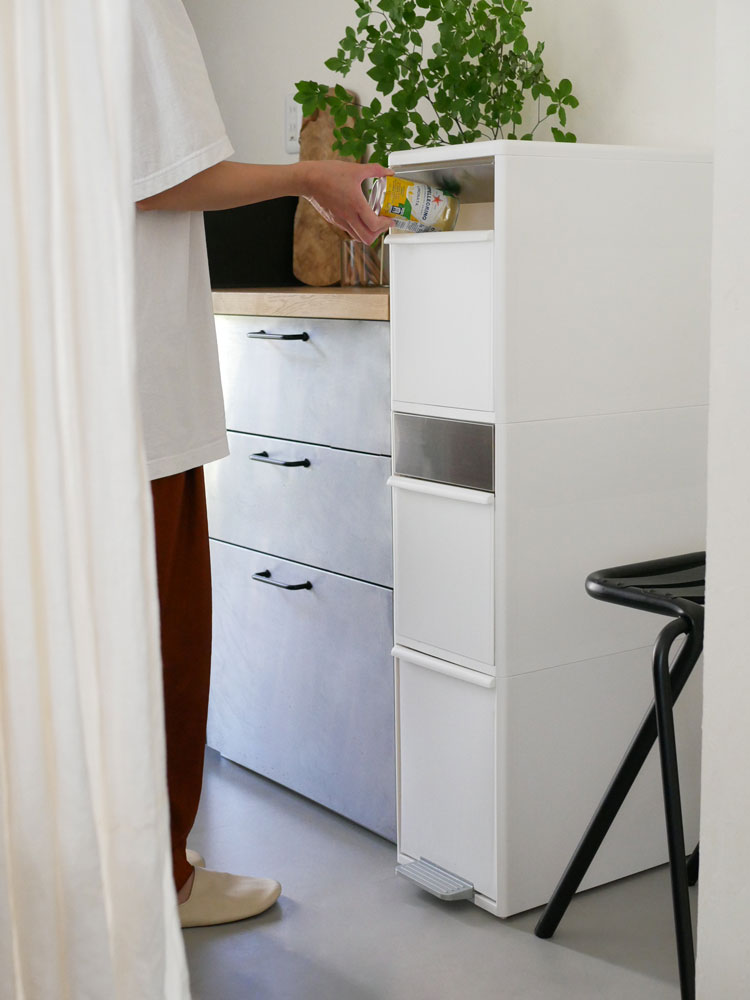 like-itライクイットの2段スイングパネルダストボックスが木製フロア上の収納キャビネットと共に配置されている様子