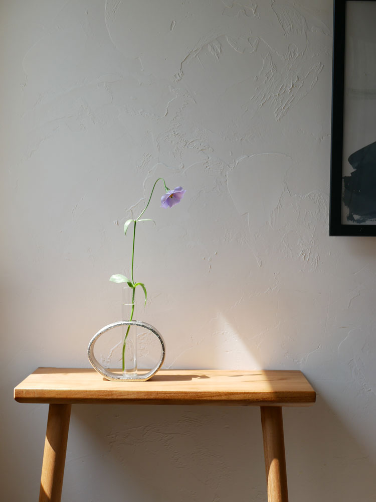 Creerクレエのアルミガラス製一輪用ベースに、一輪の室内植物が美しく配置された静物写真