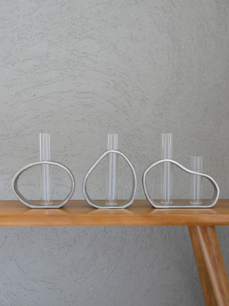 クレエの一輪用オーバル型アルミガラスベース。銀色のアルミフレームと透明ガラスで作られたスタイリッシュな花器