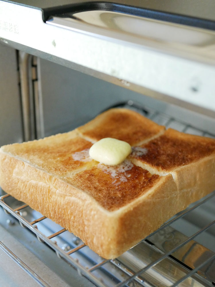 バルミューダ「The Toaster Pro」と焼きたての白パンがキッチンカウンターに置かれている様子