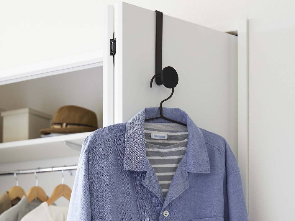 クローゼットのドアに滑り止め付きスマートドアハンガーが取り付けられ、バッグが掛けられている様子
