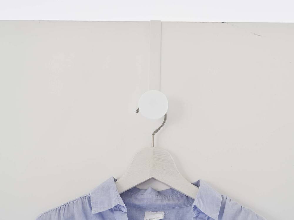 白色の滑り止め付きドアハンガーがドアに取り付けられている様子