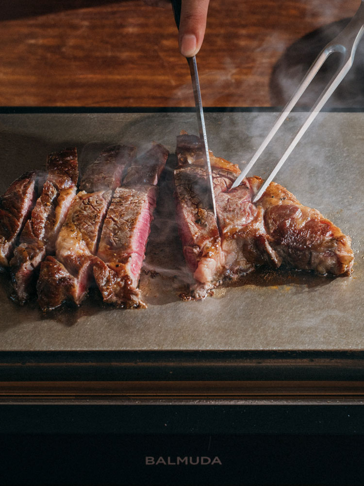 バルミューダ The Plate Proで焼かれている牛肉ステーキと調理器具のセット