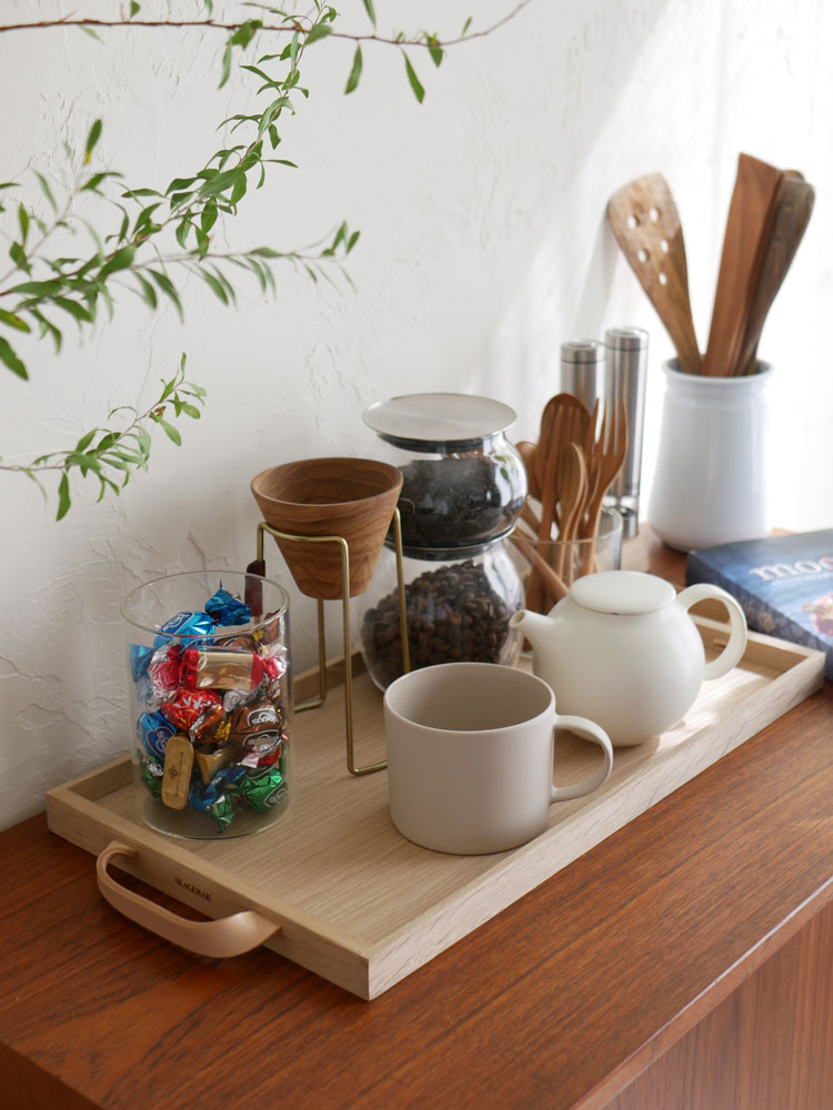 フリッツ・ハンセンのSkagerak Norrトレイにオーク材とレザーを使用し、カップや食器が美しく配置されたテーブルセッティング