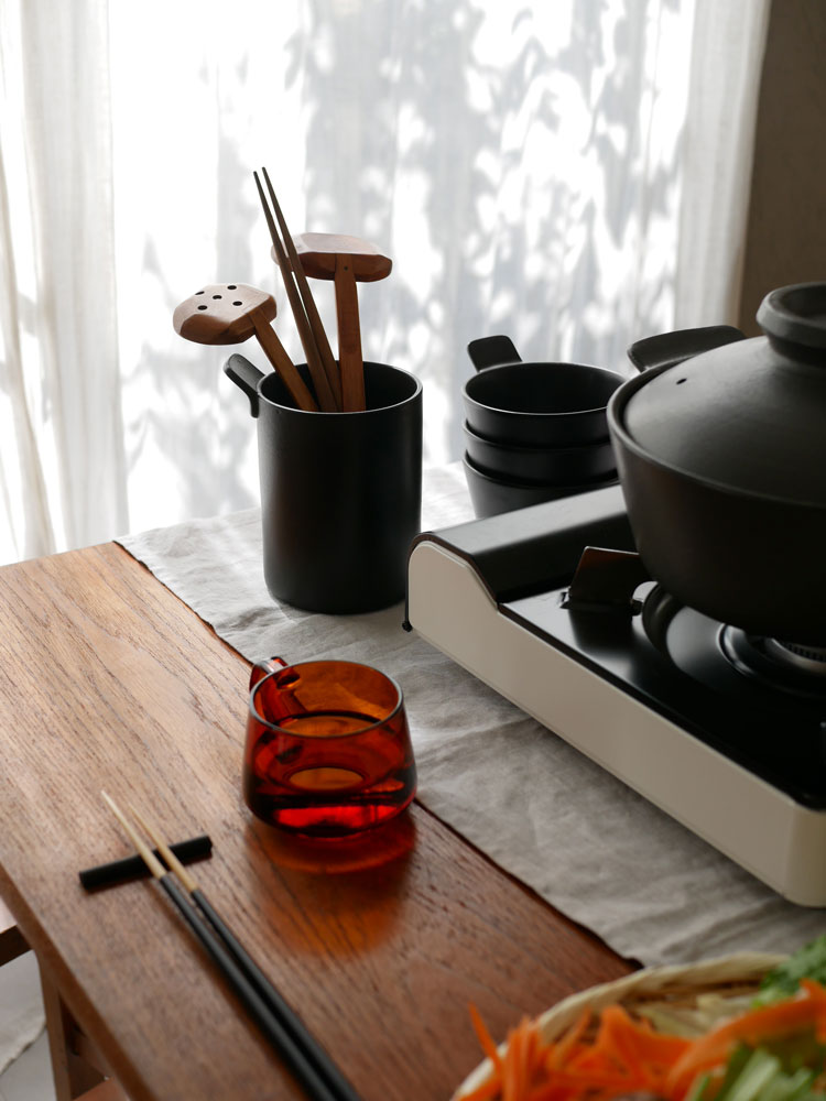 sarasa designの1年中使える耐熱陶器製マルチ土鍋、とんすい、ツールスタンドがテーブル上に並んだキッチンセット