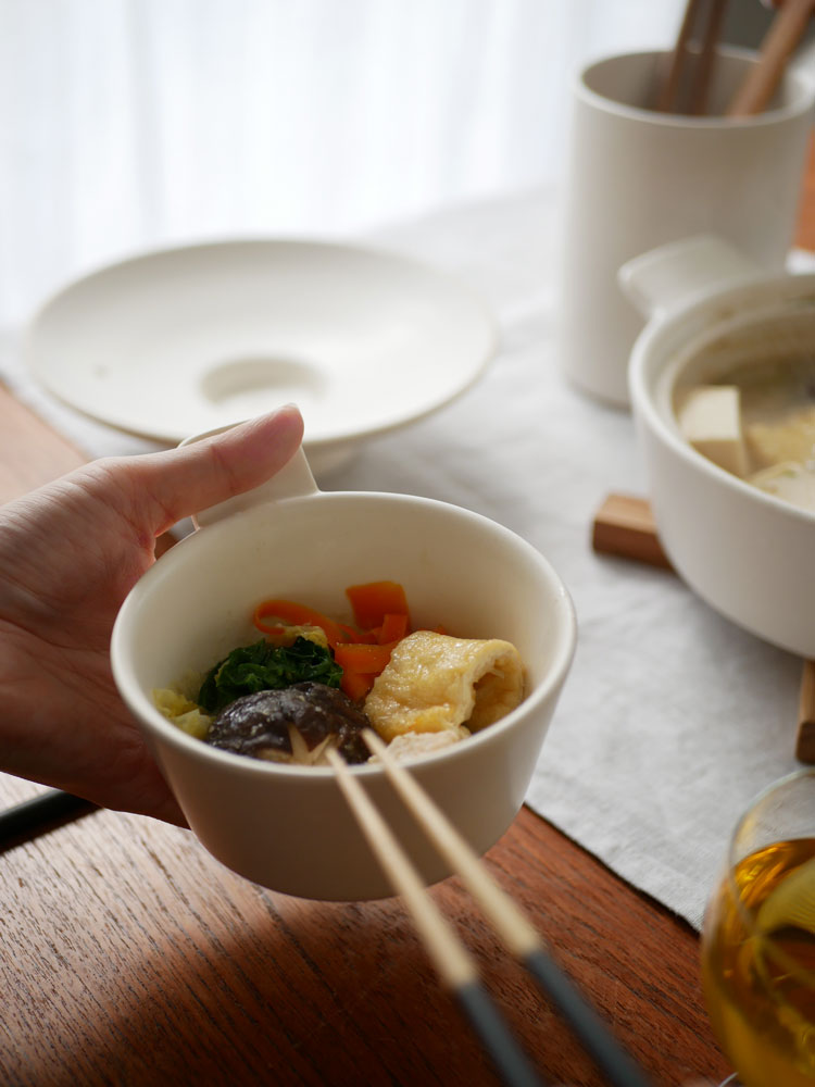 サラサデザインの耐熱陶器マルチ土鍋にスープが入っており、箸や食器、ツールスタンドがセットで配置された食卓の様子