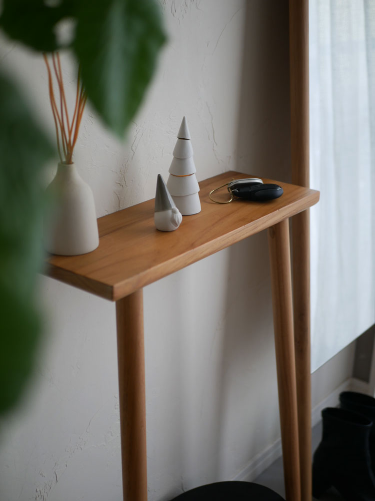 木製のエンドテーブルの上に【Comore Sun】癒しの九谷焼サンタクロースが置かれ、花鉢や花瓶と共にディスプレイされている様子