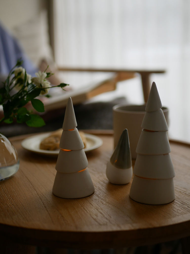 灯りが漏れる九谷焼のクリスマスツリーに飾られたLEDキャンドル