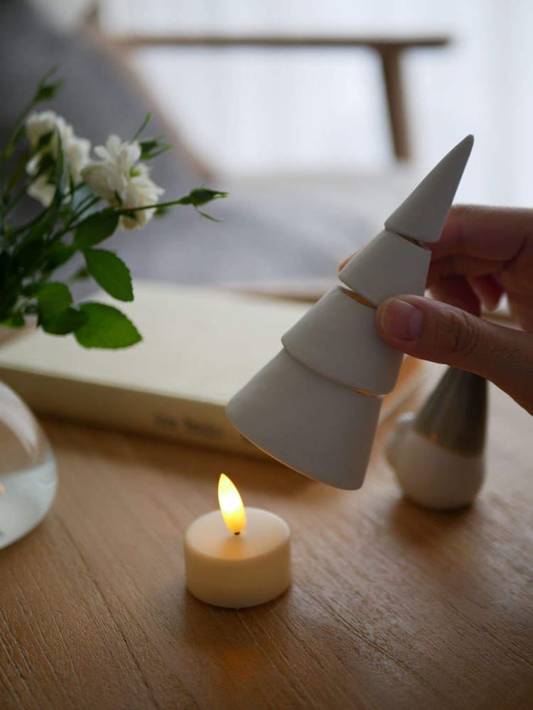 灯りが漏れる花坂陶石製の九谷焼クリスマスツリーとLEDキャンドルの静物写真