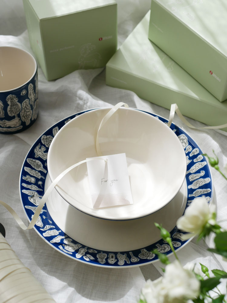 イッタラ×ミナ ペルホネン フォレストライフ2023限定カラーの磁器製食器セット。テーブルクロスの上にカップ、ボウル、プレートが配置されている。