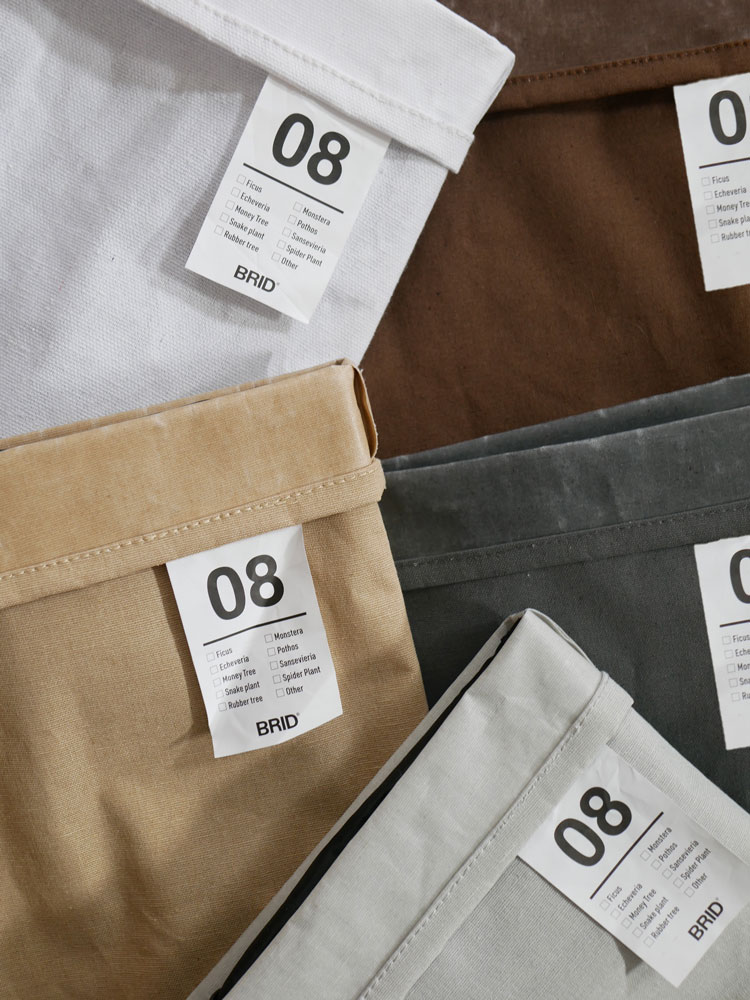 グレーのBRIDブリッドプランツカバー。デニム風の素材に銀色のボタンとラベルが付いており、土を隠すデザイン