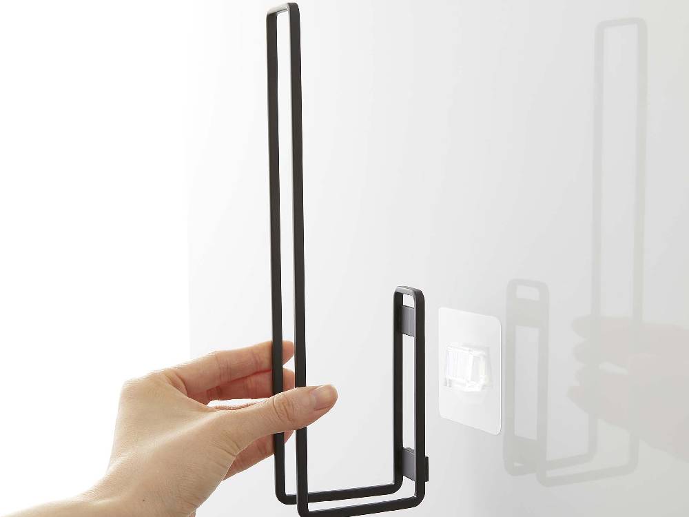 タワー型スチールトイレットペーパーホルダーにフィルムフックが取り付けられたデザインの写真